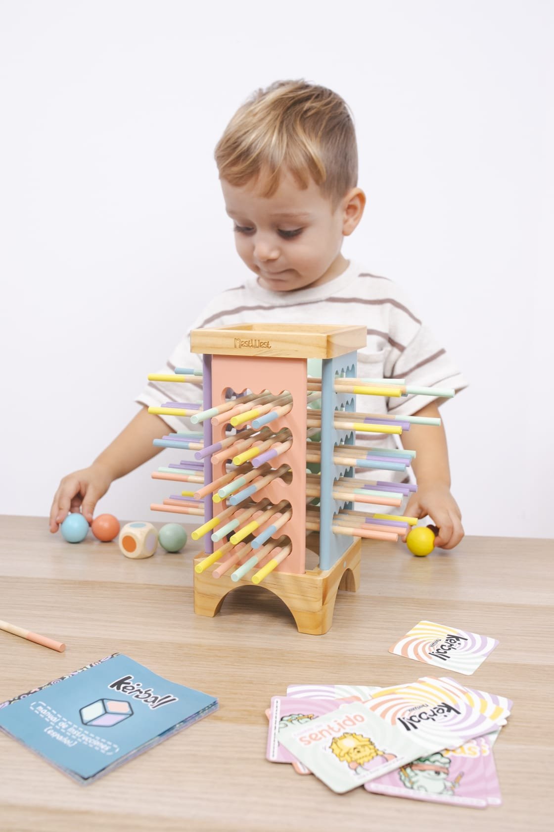 Un niño con Kerball Up, sus bolas, dado y cartas sobre la mesa
